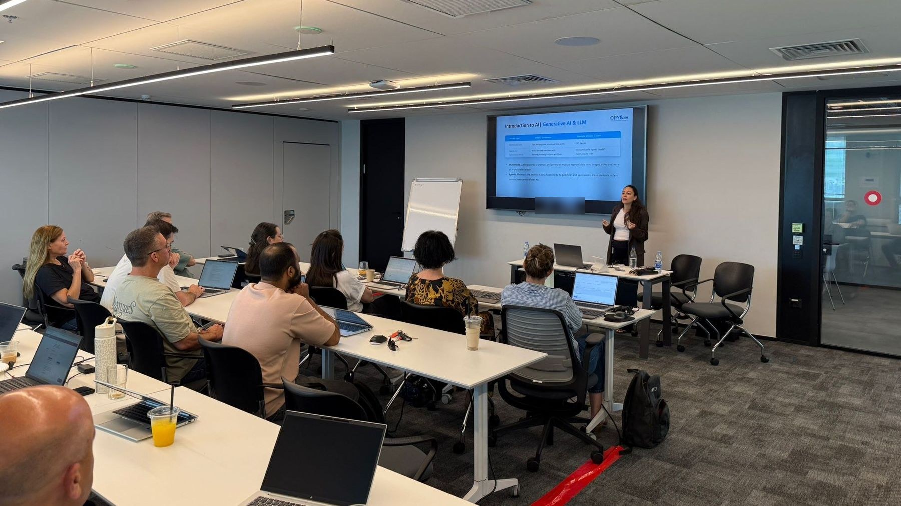 A workshop room: participants at laptops with Copilot open, a trainer at the front.